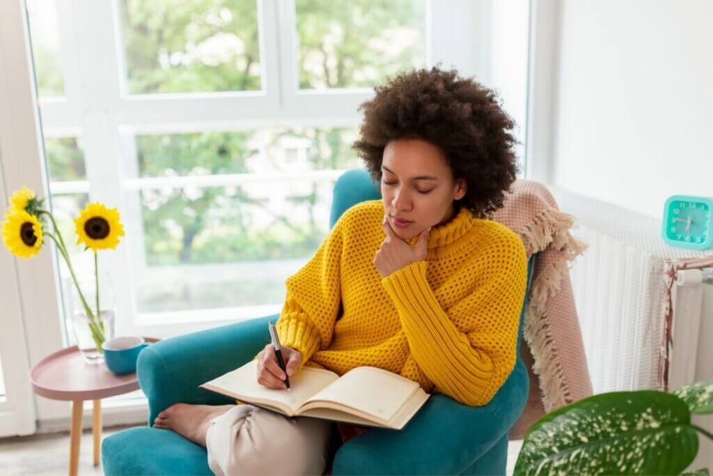 10 Estrategias Prácticas para Mejorar tu Nivel de Francés 2 Joven escribiendo en frances en su diario para mejorar su nivel de francés.