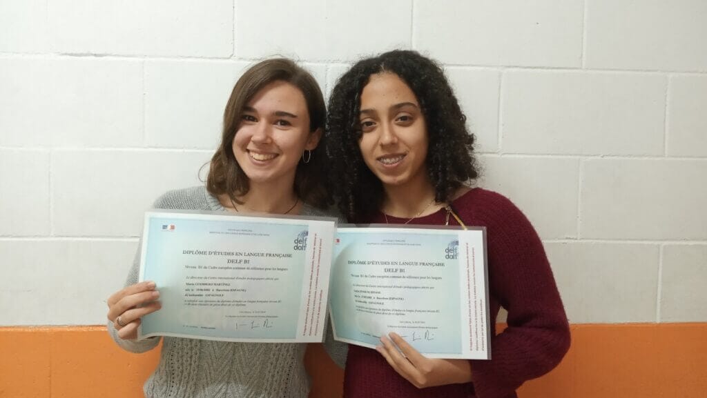 Estudiantes sonriendo con el diploma delf dalf en sus manos